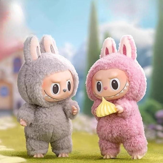 Two plush toys in bunny costumes standing on a grassy area with a blurred background.